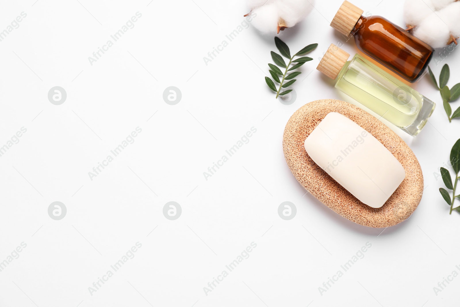 Photo of Different cosmetic products, cotton flowers and leaves on white background, flat lay. Space for text