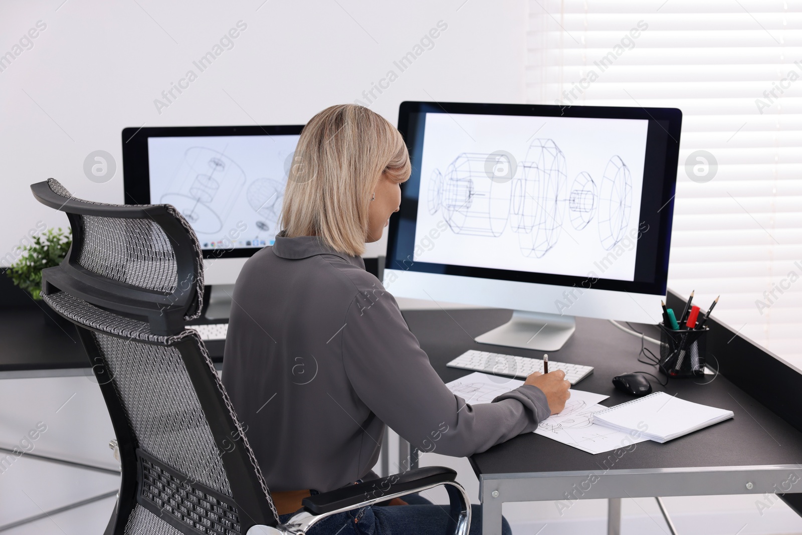 Photo of Architect making engineering drawing at table in office