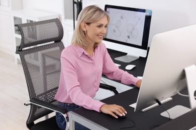 Architect making digital engineering drawing on computer at table in office