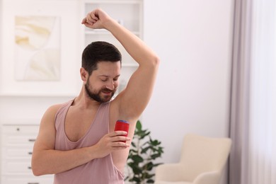 Photo of Man applying solid deodorant at home. Space for text