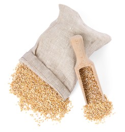 Dry wheat groats, overturned burlap sack and wooden scoop isolated on white, top view