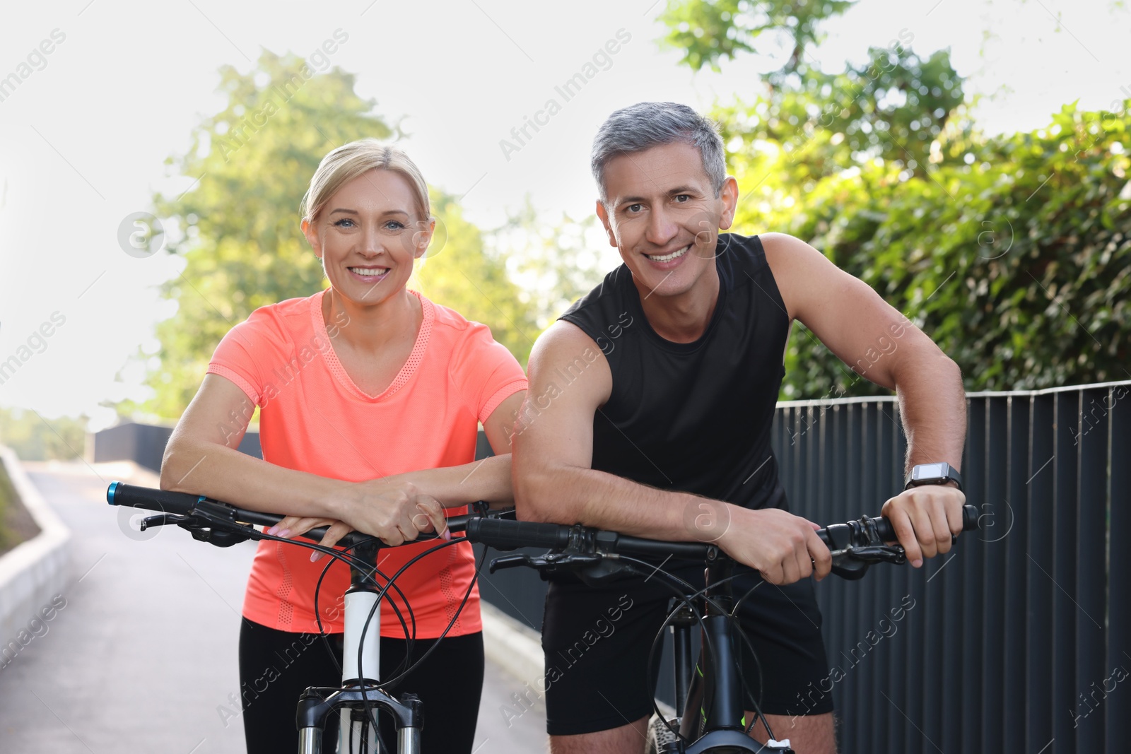 Photo of Happy couple with bicycles in park. Healthy lifestyle