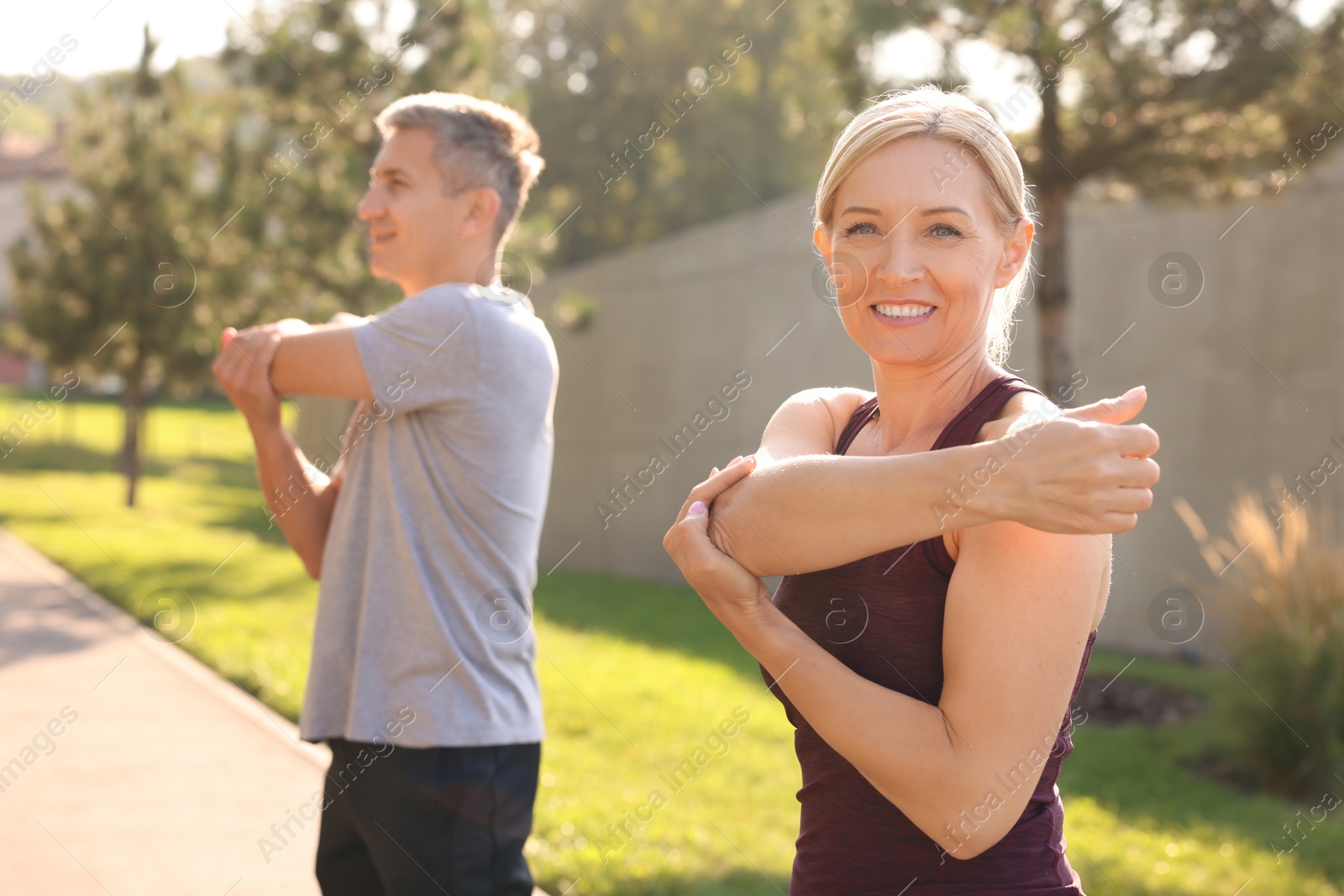 Photo of Happy couple doing exercises in park, selective focus