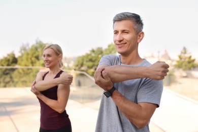 Happy couple doing exercises in park, selective focus