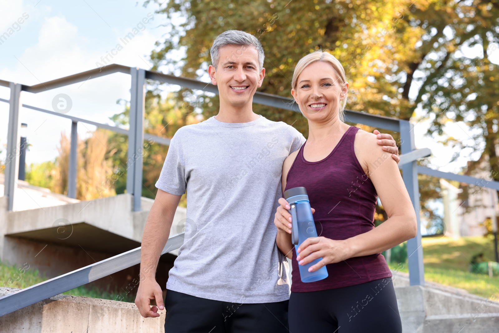 Photo of Happy couple with bottle of water in park