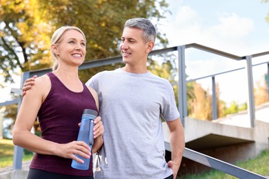 Photo of Happy couple with bottle of water in park