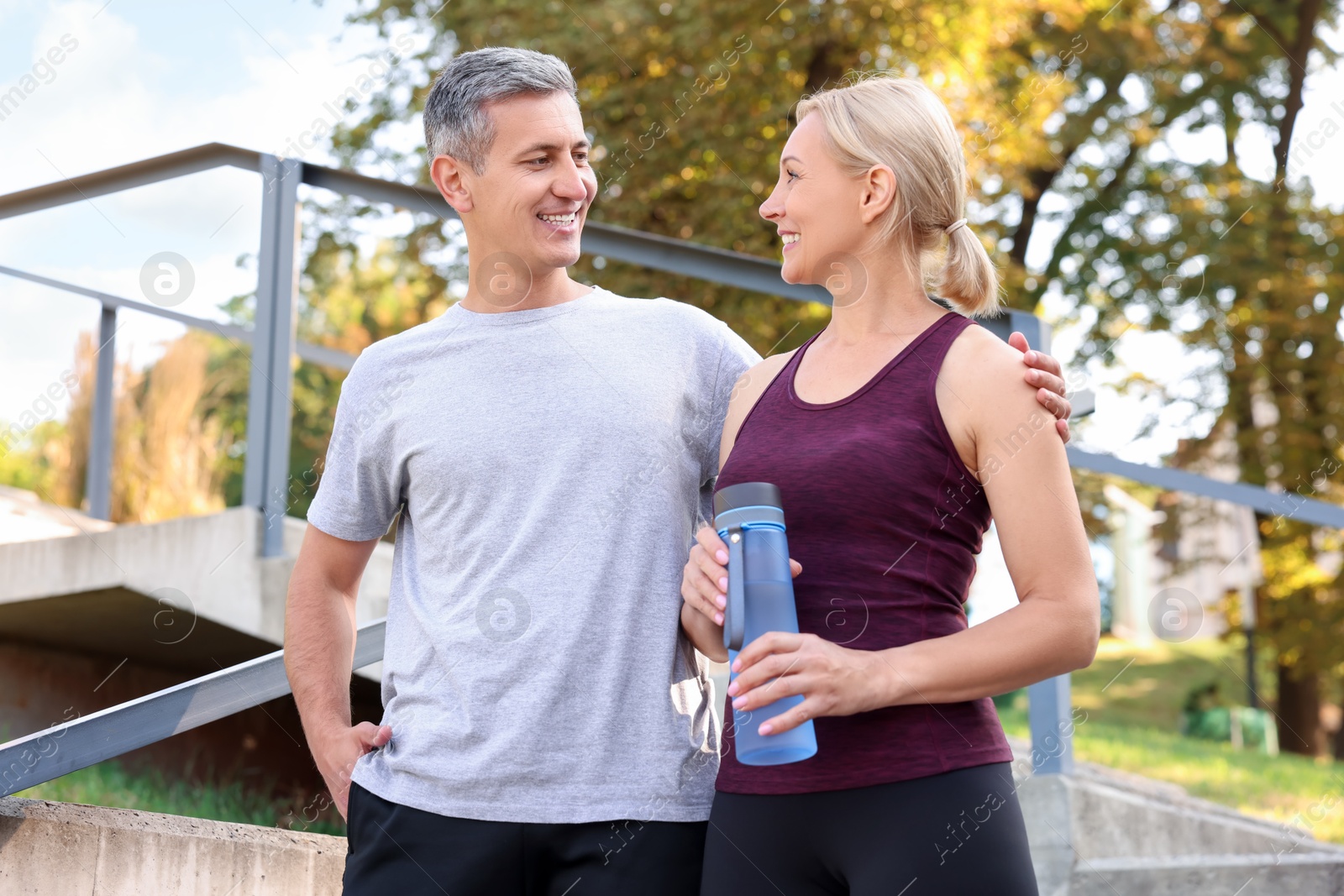 Photo of Happy couple with bottle of water in park