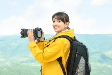 Photo of Photographer with backpack and camera in mountains