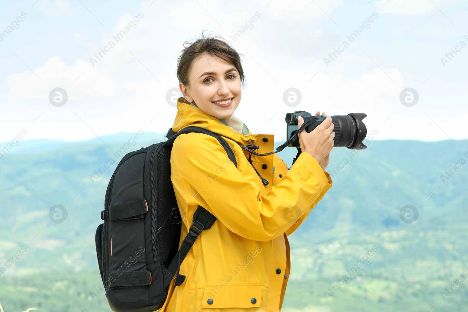 Photo of Photographer with backpack and camera in mountains