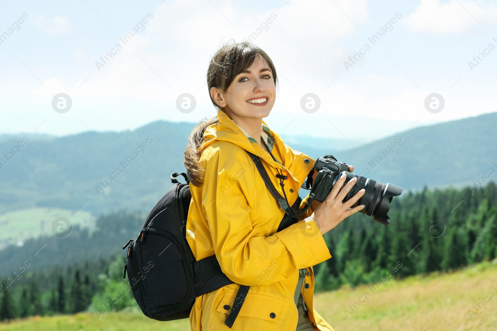 Photo of Photographer with backpack and camera in mountains