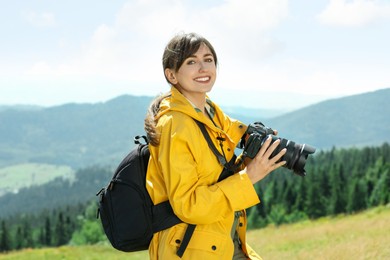 Photo of Photographer with backpack and camera in mountains