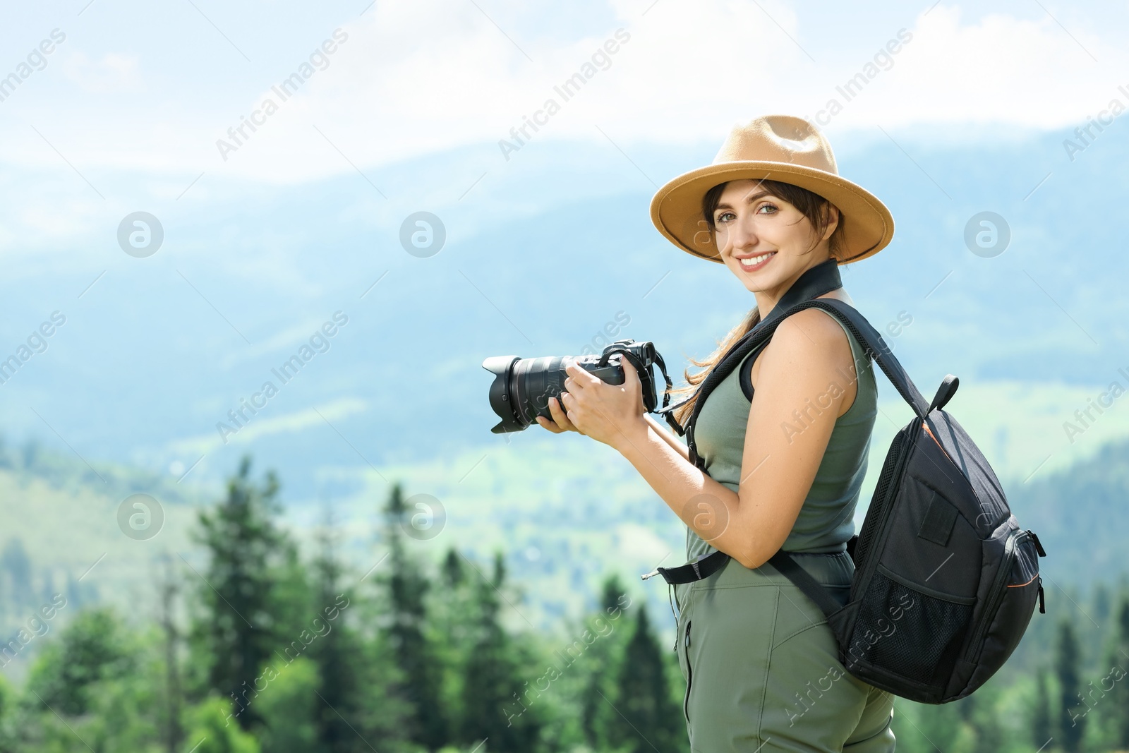 Photo of Photographer with backpack and camera in beautiful mountains. Space for text