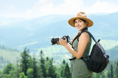 Photo of Photographer with backpack and camera in beautiful mountains. Space for text