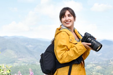 Photographer with backpack and camera in beautiful mountains