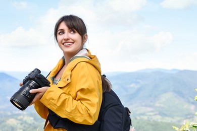 Photographer with backpack and camera in beautiful mountains. Space for text