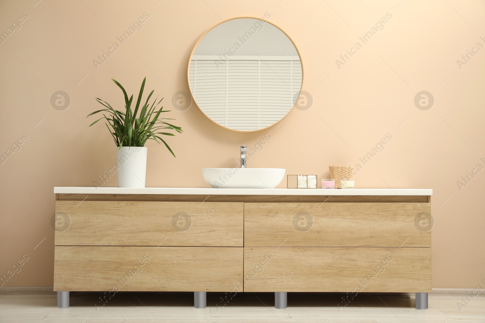 Photo of Stylish vanity, houseplant, sink and mirror in bathroom