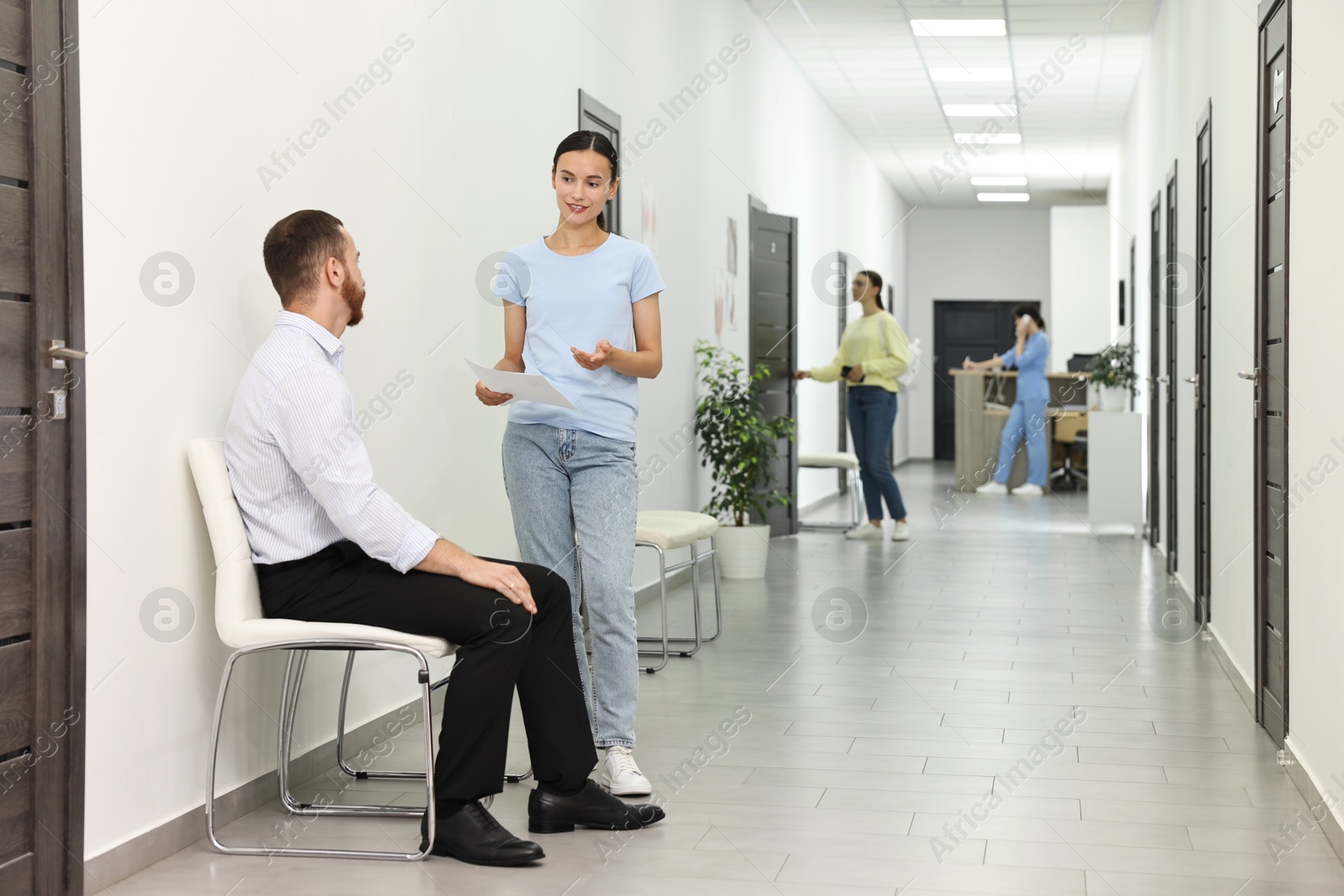 Photo of Patients waiting for appointment and doctor in hospital hallway, selective focus