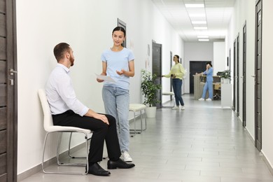 Patients waiting for appointment and doctor in hospital hallway, selective focus