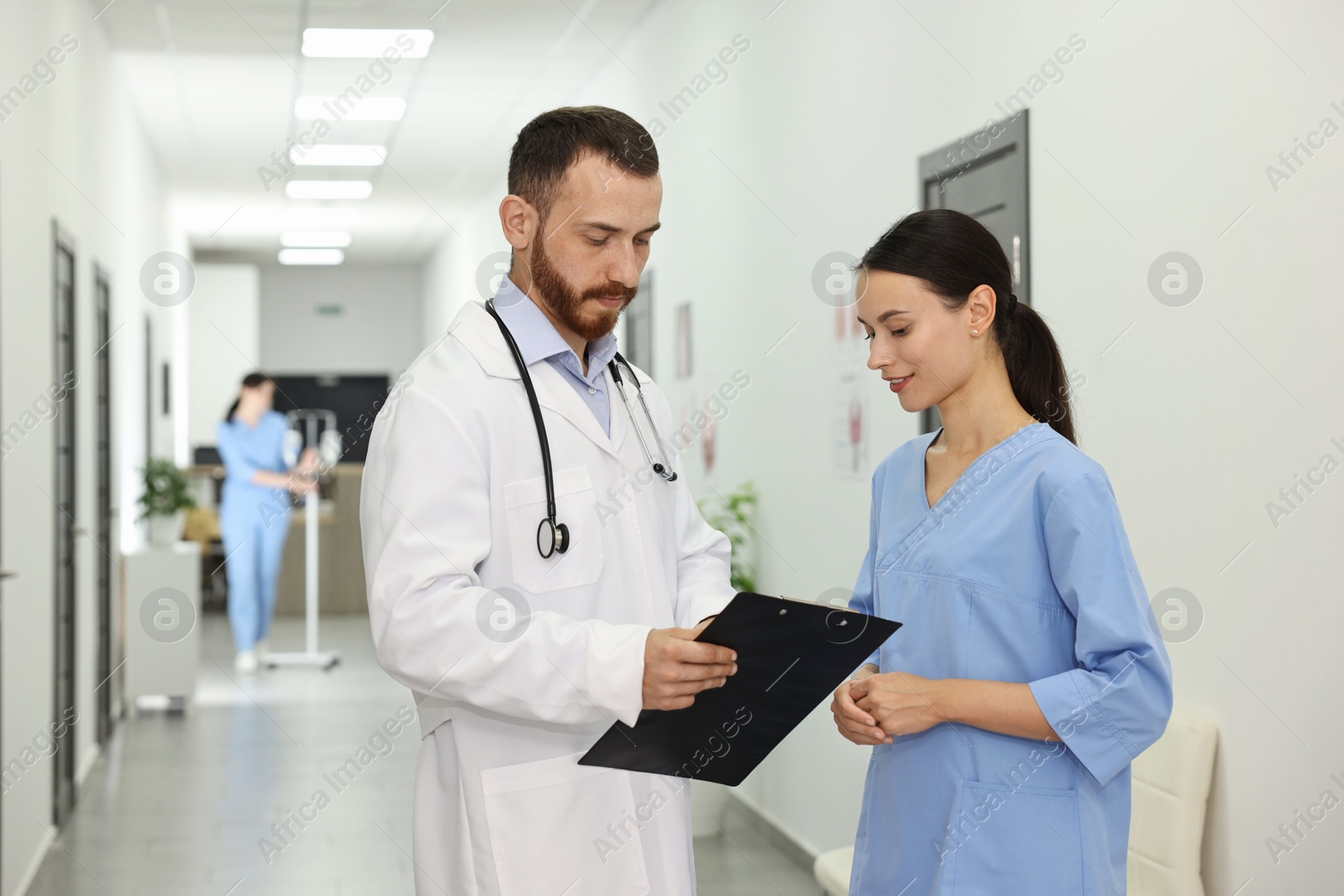 Photo of Doctor and nurse talking in hospital hallway