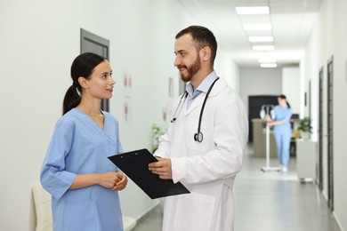 Doctor and nurse talking in hospital hallway