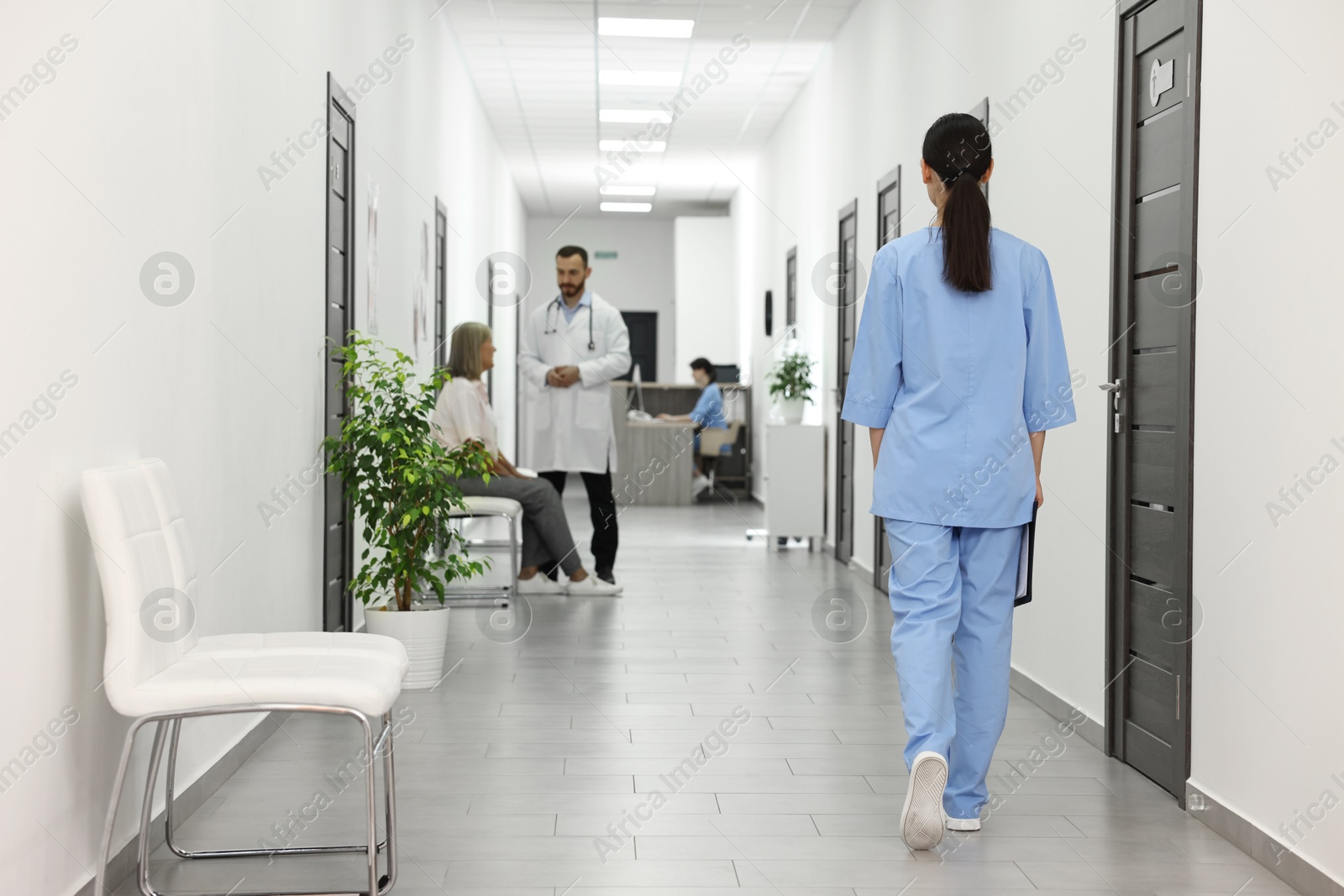 Photo of Doctors and patient in hospital hallway, selective focus