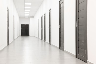 View of empty hospital corridor with wooden doors