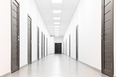 View of empty hospital corridor with wooden doors