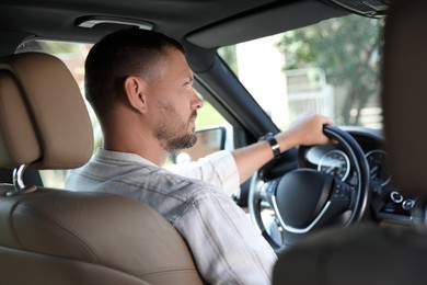 Man holding steering wheel while driving car