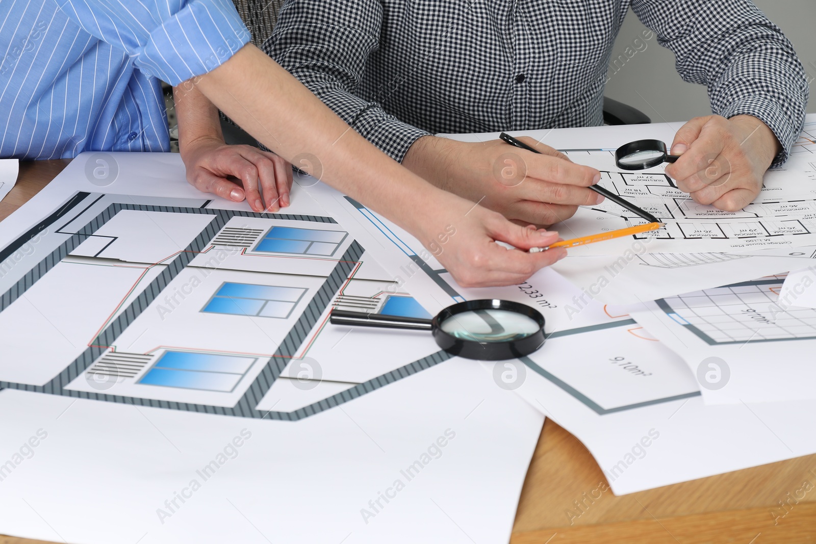 Photo of Architects working with project at table in office, closeup