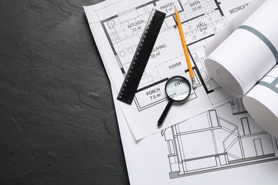 Photo of Different architectural drawings, pencil, ruler and magnifying glass on grey textured table, flat lay. Space for text