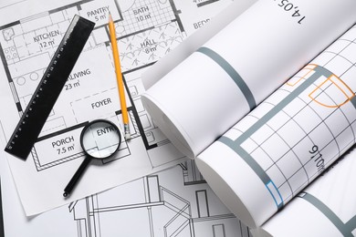 Different architectural drawings, pencil, ruler and magnifying glass on white table, flat lay