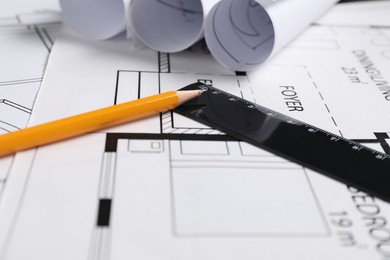 Photo of Different architectural drawings, ruler and pencil on table, closeup