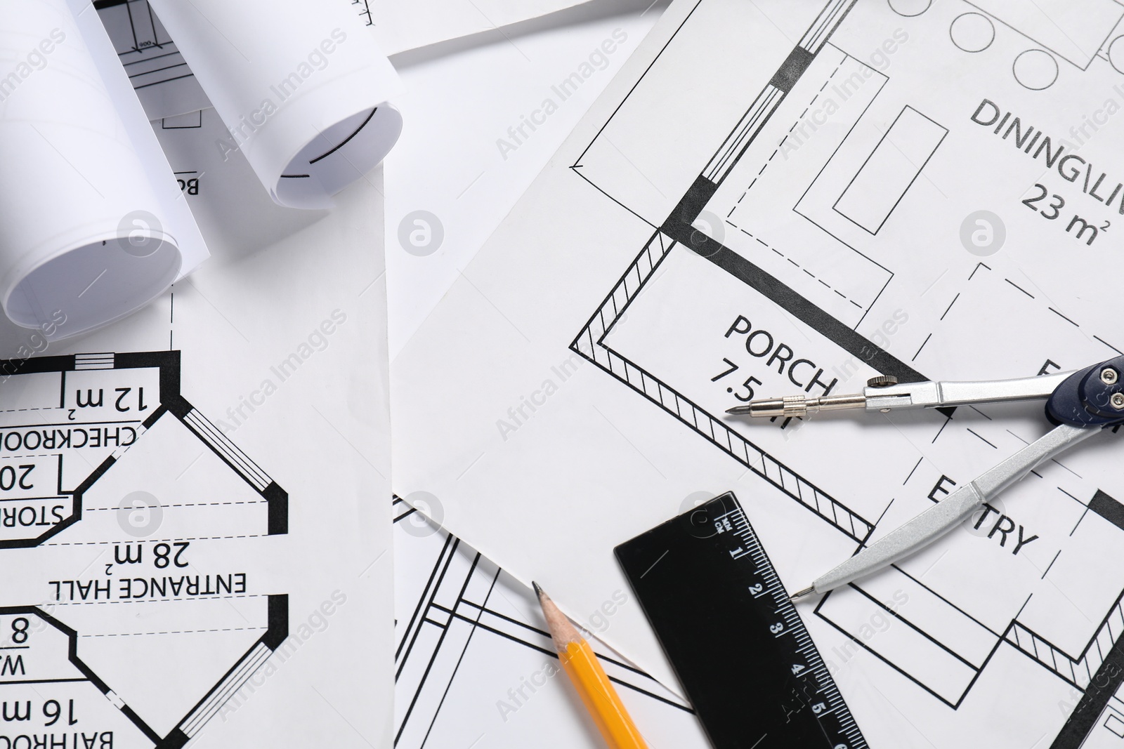 Photo of Different architectural drawings, divider, ruler and pencil on table, flat lay