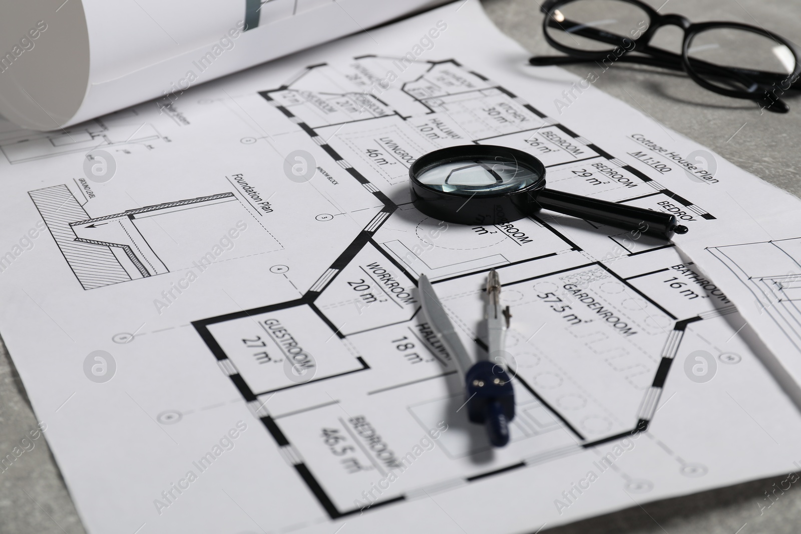 Photo of Different engineering drawings and tools on grey table