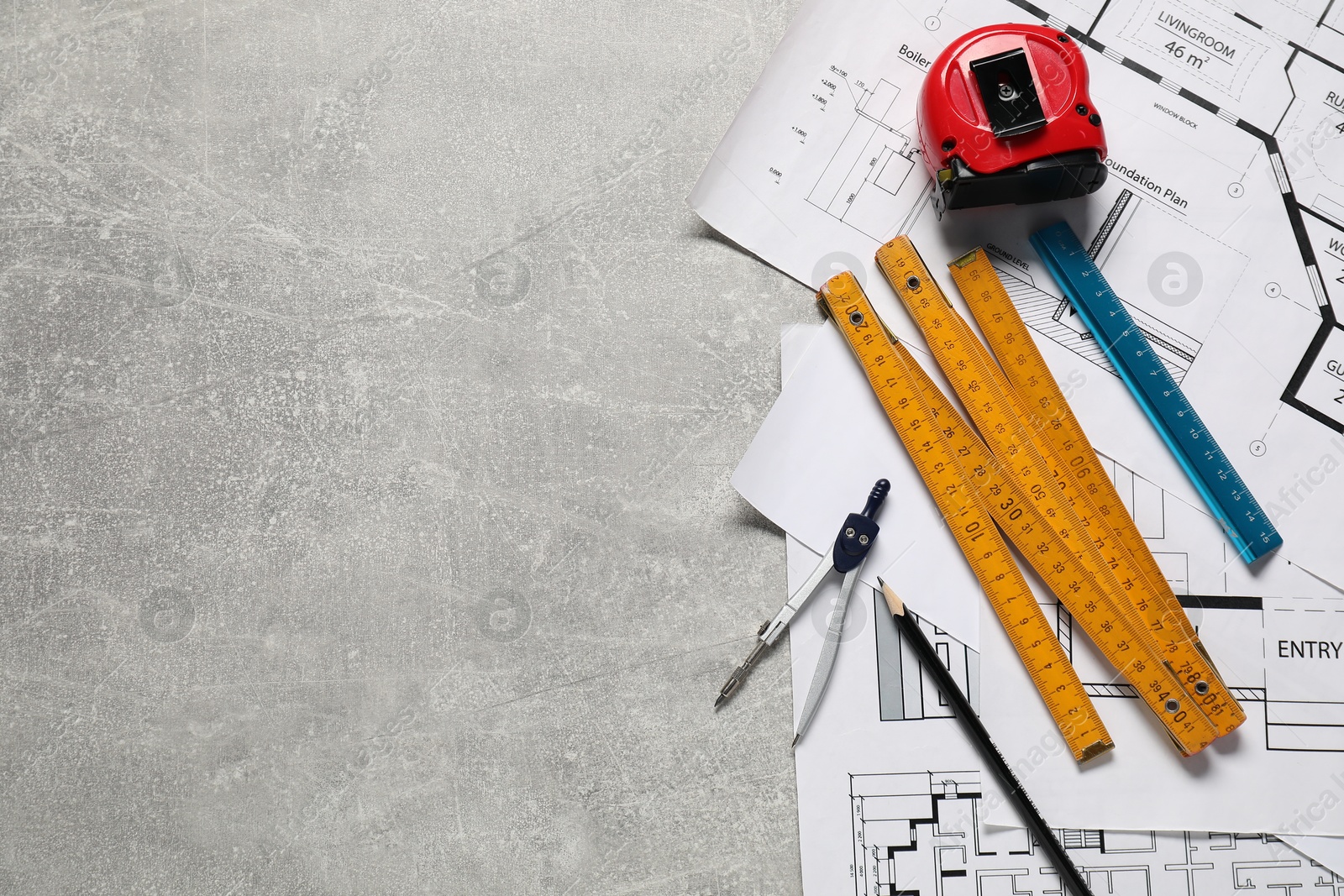 Photo of Different engineering drawings and tools on grey textured table, flat lay. Space for text