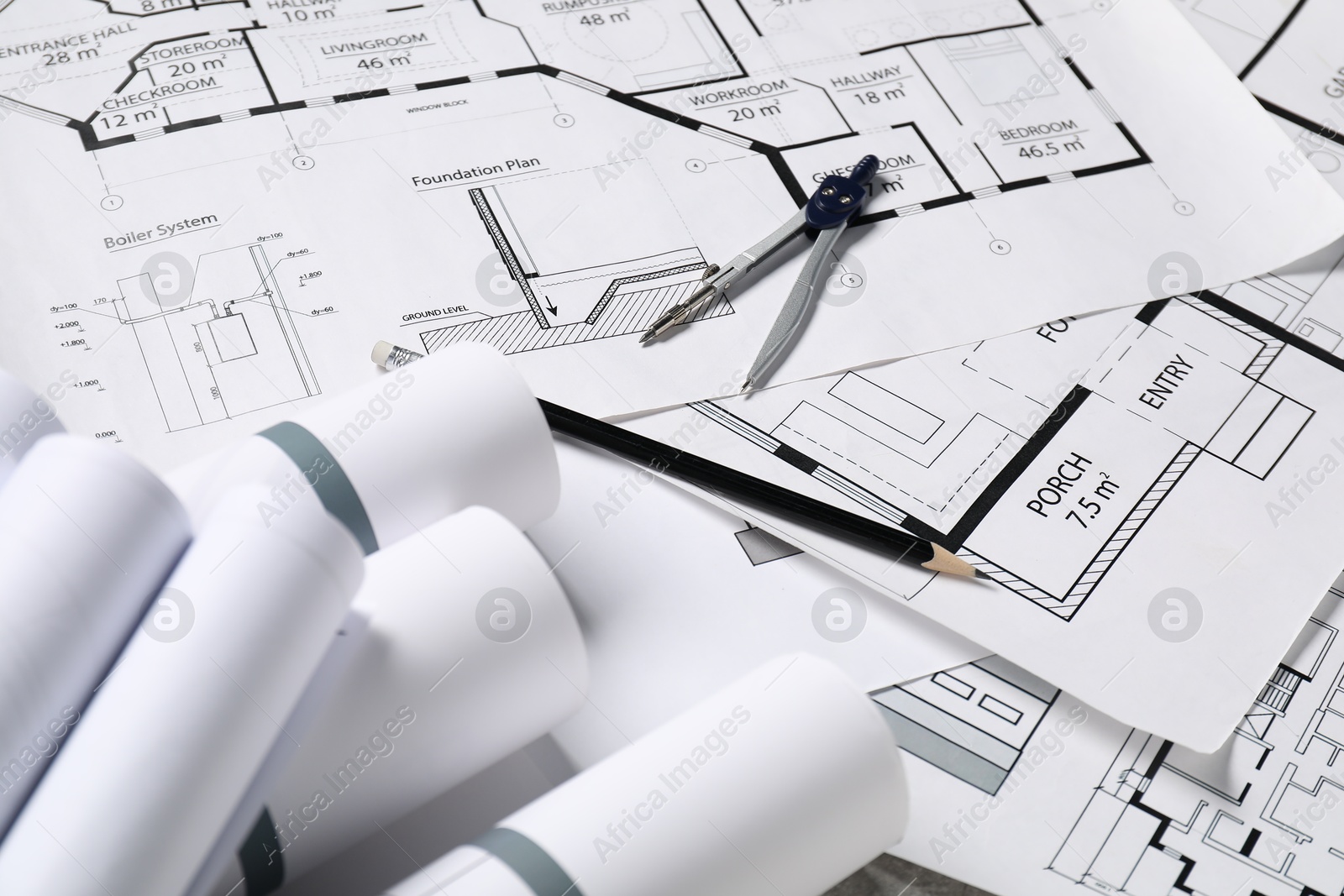 Photo of Different engineering drawings, pencil and divider on table, closeup