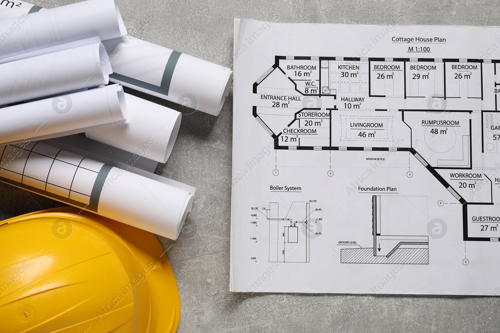 Photo of Different engineering drawings and hard hat on grey textured table, flat lay