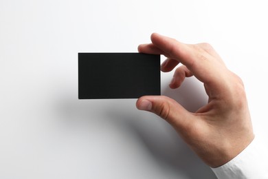 Photo of Woman with blank business card on light grey background, closeup. Mockup for design