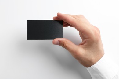 Photo of Woman with blank business card on light grey background, closeup. Mockup for design