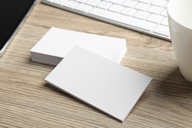 Blank business cards and keyboard on wooden table. Mockup for design