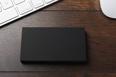 Photo of Blank business cards and keyboard on wooden table. Mockup for design