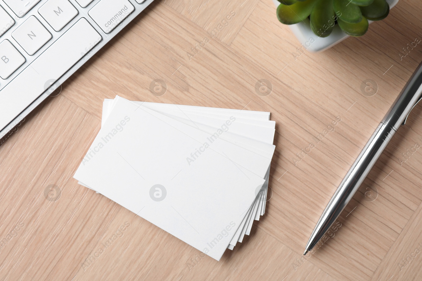 Photo of Blank business cards, pen and keyboard on wooden table, flat lay. Mockup for design