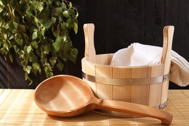 Sauna equipment. Bucket, towel and ladle on bamboo bench