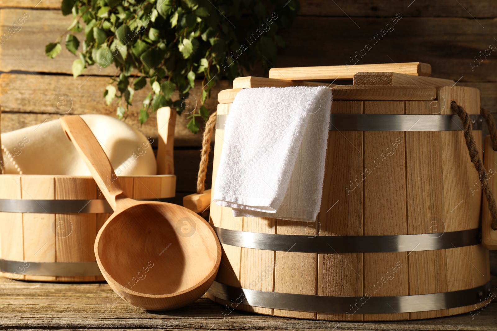 Photo of Sauna equipment. Buckets, ladle and towel on wooden surface