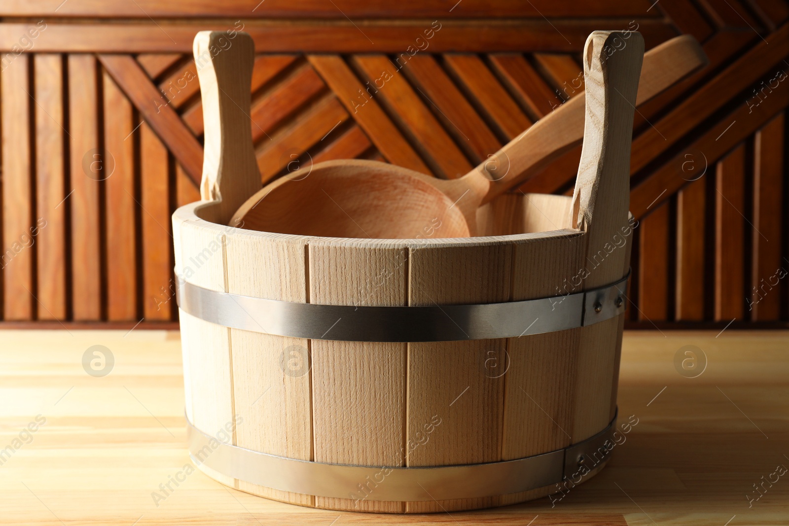 Photo of Sauna equipment. Bucket and ladle on wooden surface, closeup