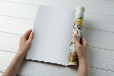 Photo of Woman reading magazine at white wooden table, closeup. Mockup for design