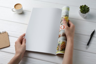 Woman reading magazine at white wooden table, closeup. Mockup for design