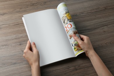 Photo of Woman reading magazine at wooden table, closeup. Mockup for design