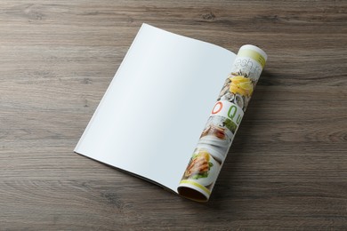 Open magazine with blank page on wooden table, top view. Mockup for design