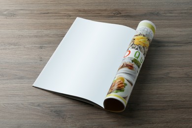 Open magazine with blank page on wooden table. Mockup for design